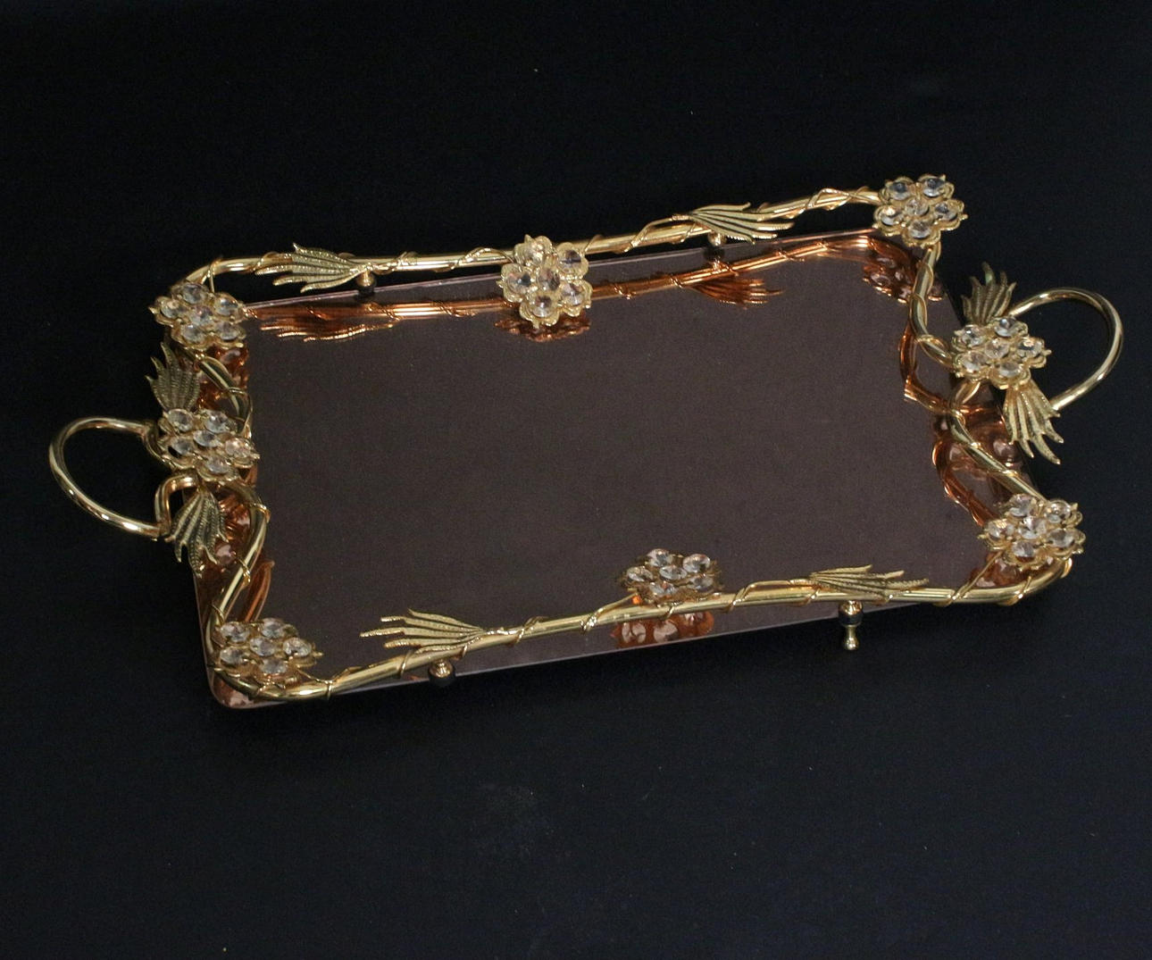 Spegelbricka med blommig dekoration.