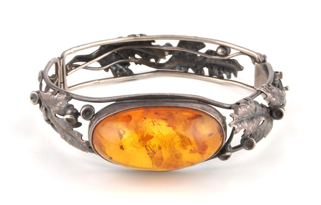 ARMREIF. handgjorda. Skena av skulpturala ekblad, inramad bärnsten.