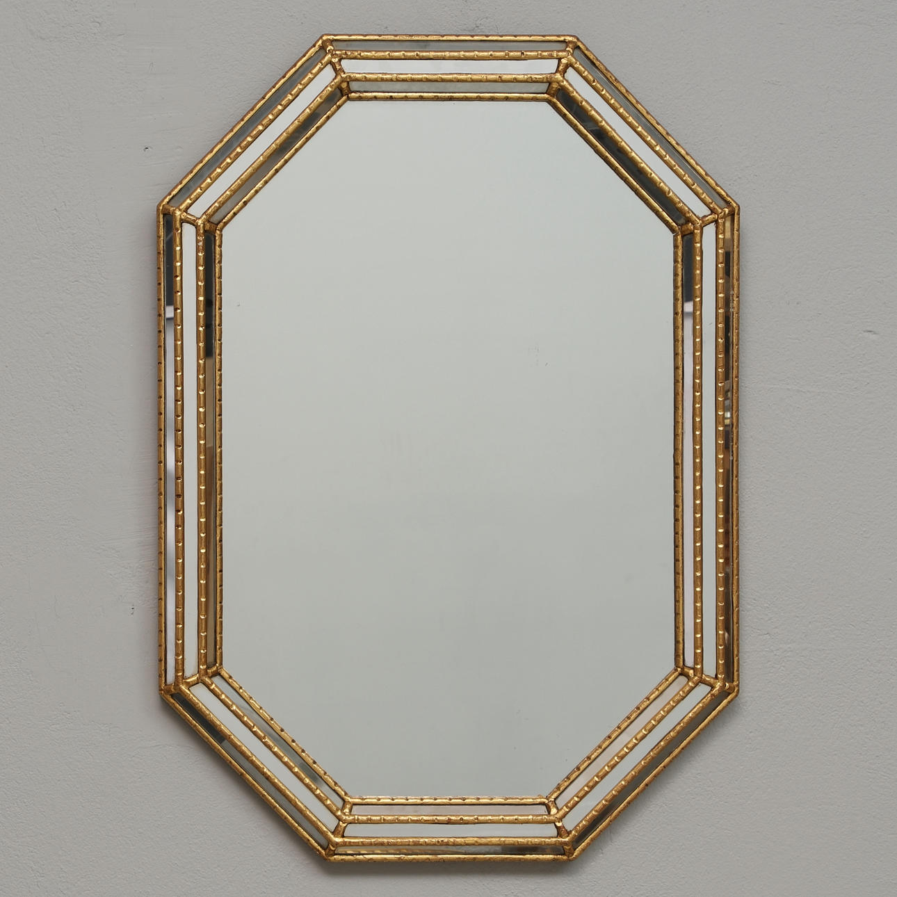 A 20th century octagonal, gold-bronzed wood mirror.