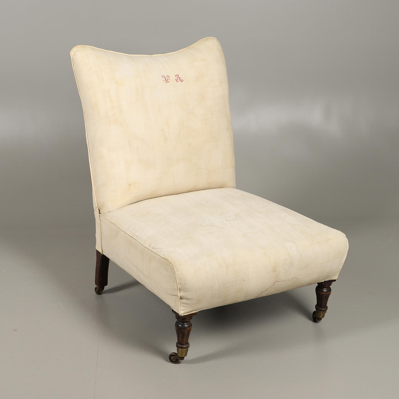 AN UPHOLSTERED LOW SEAT CHAIR.