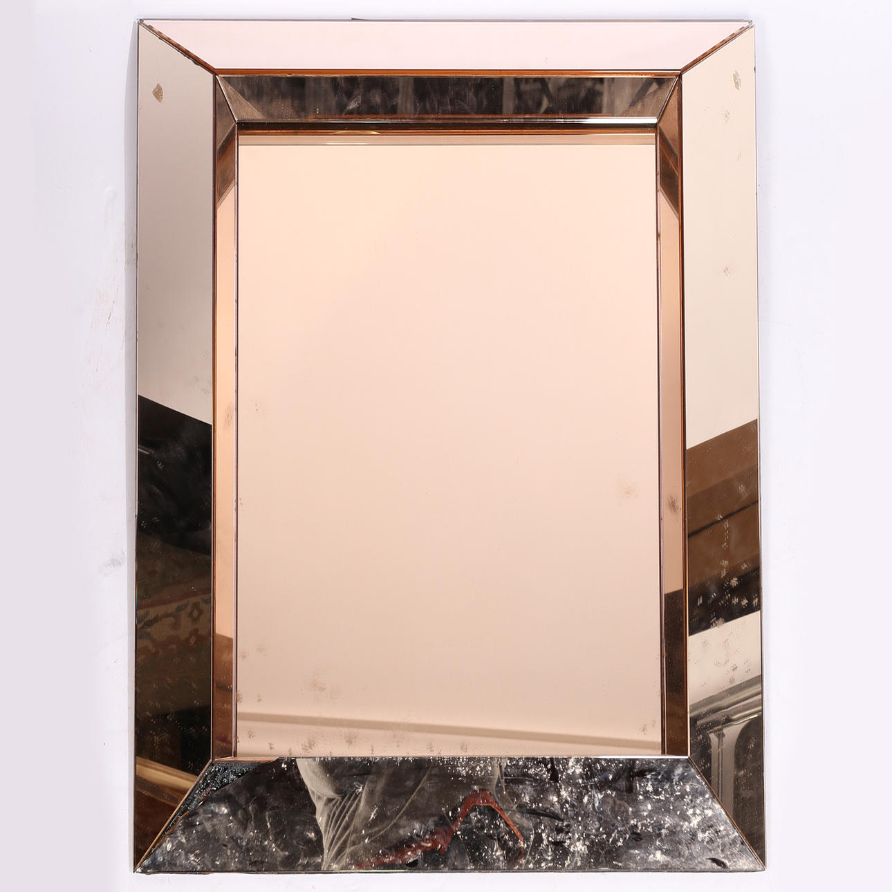A COPPER EFFECT WALL MIRROR.