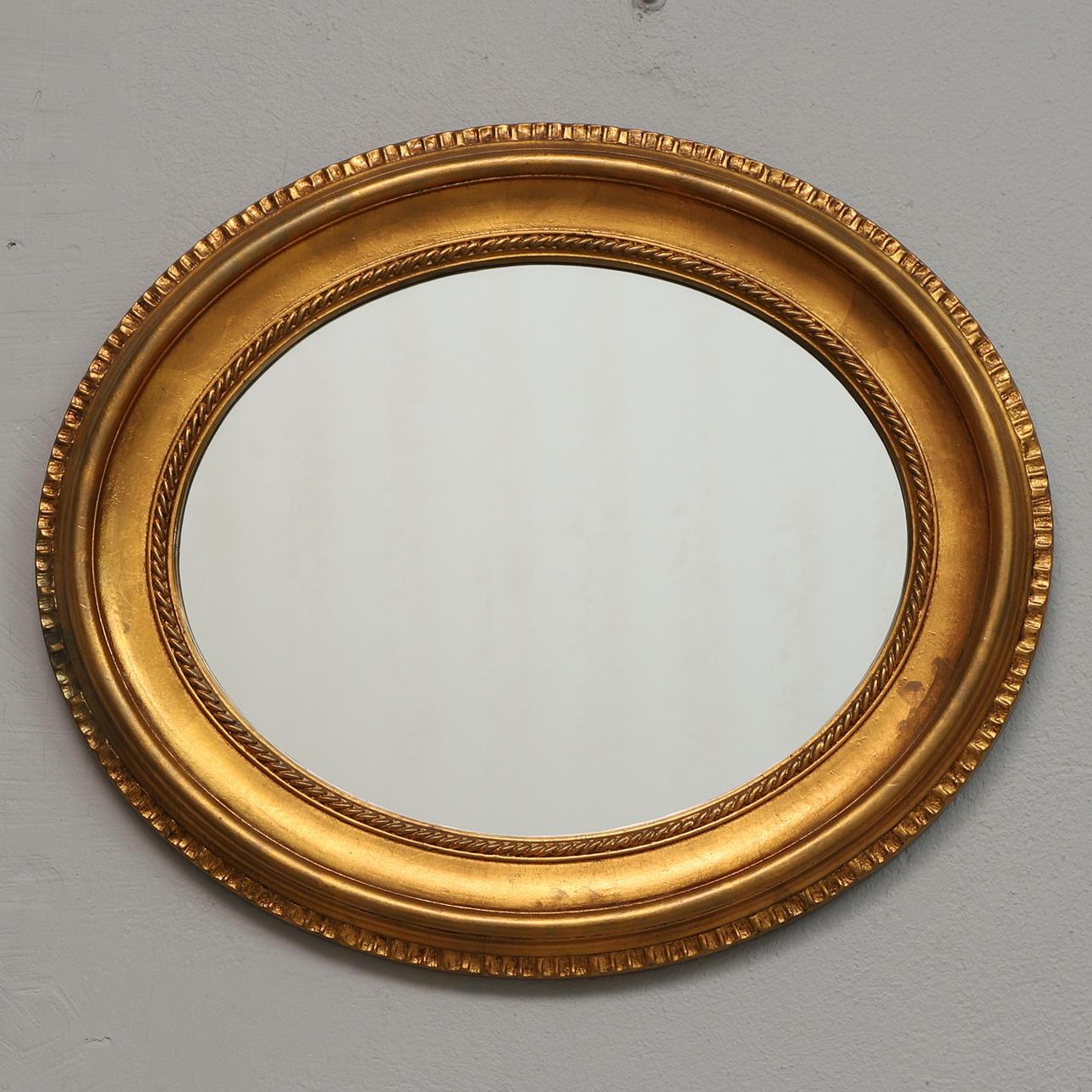 A mirror, oval, gilt frame, 20th century.
