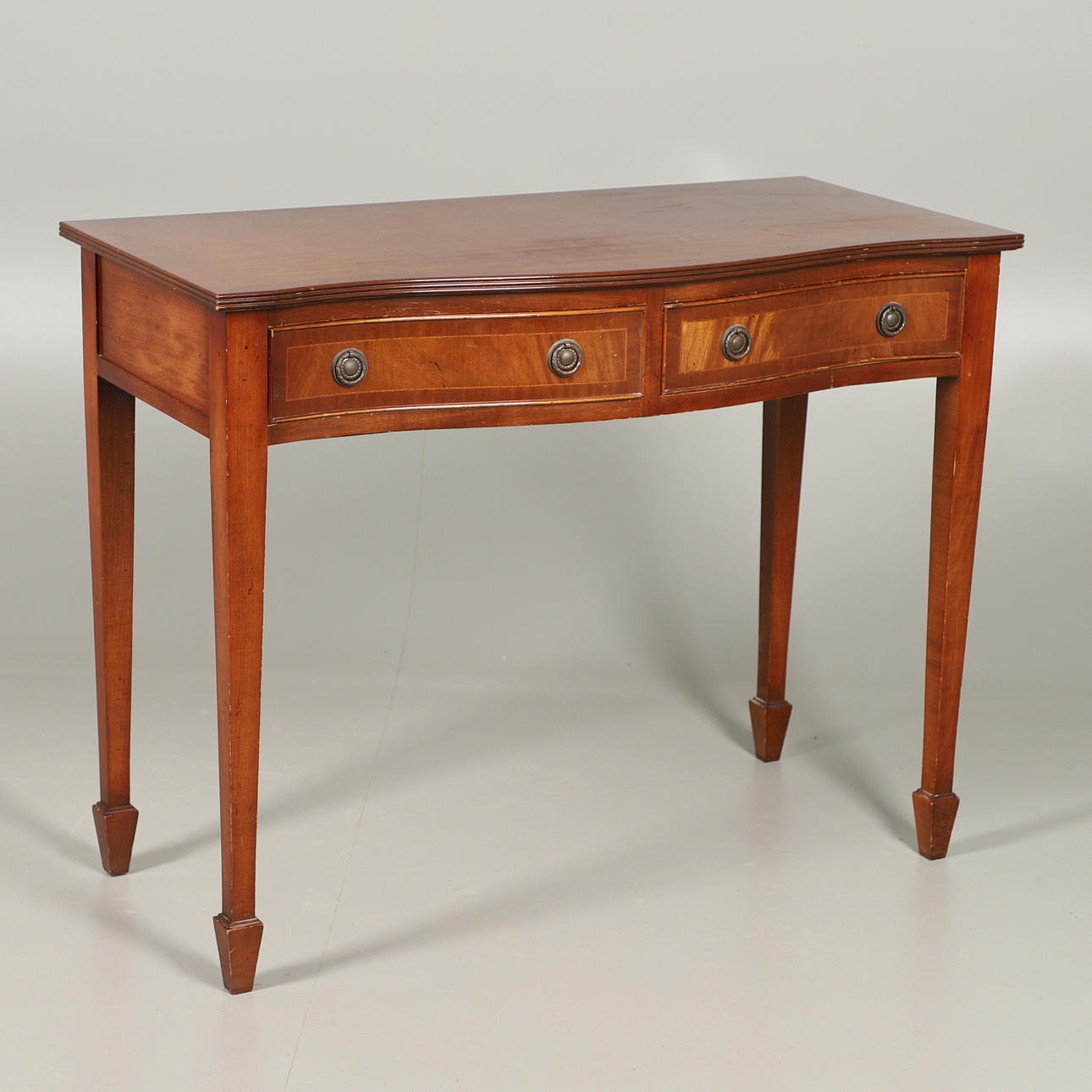 A MAHOGANY SERPENTINE FRONTED SIDE TABLE.