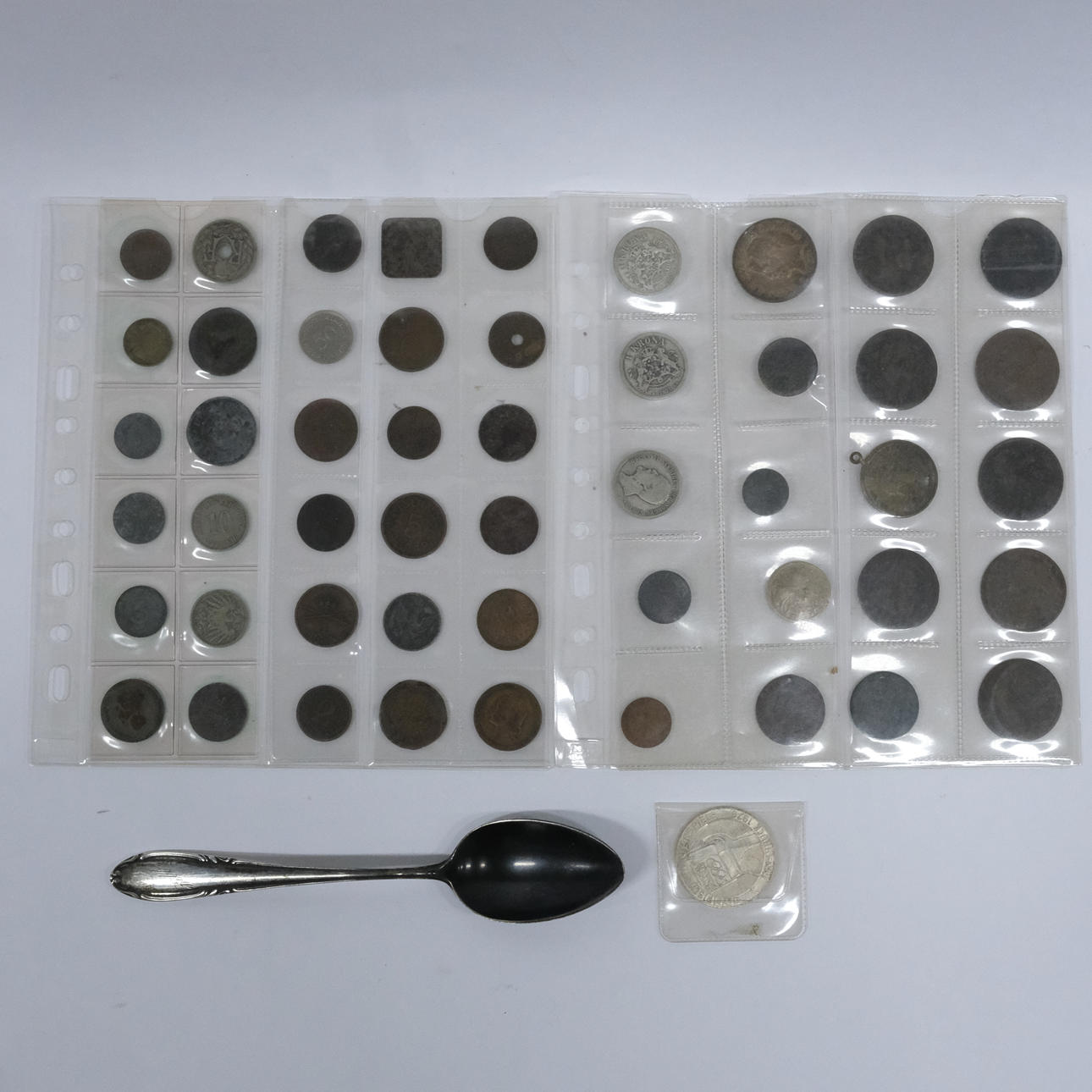 UN MONTÓN DE MONEDAS Y CUCHARA DE PLATA.