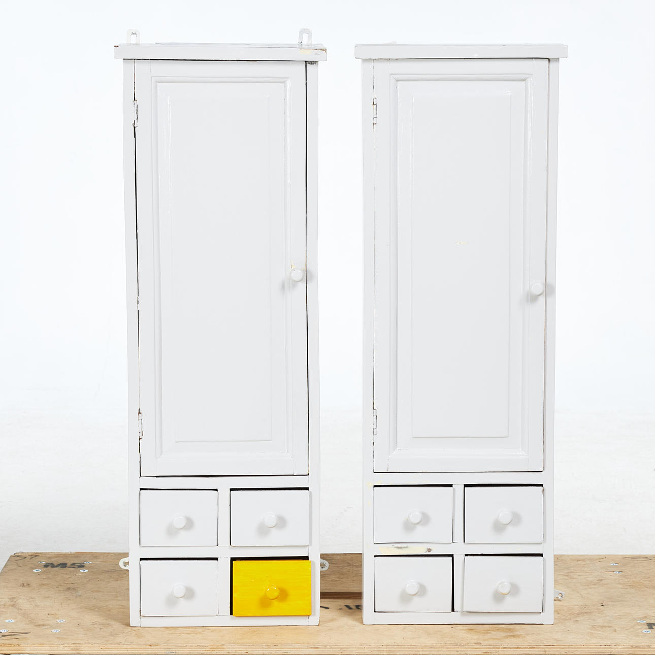 WALL CABINET, 2 pcs, drawers and cabinet part with back shelf, pull knobs in wood, white and yellow painted, marked “Bruka design sweden”.