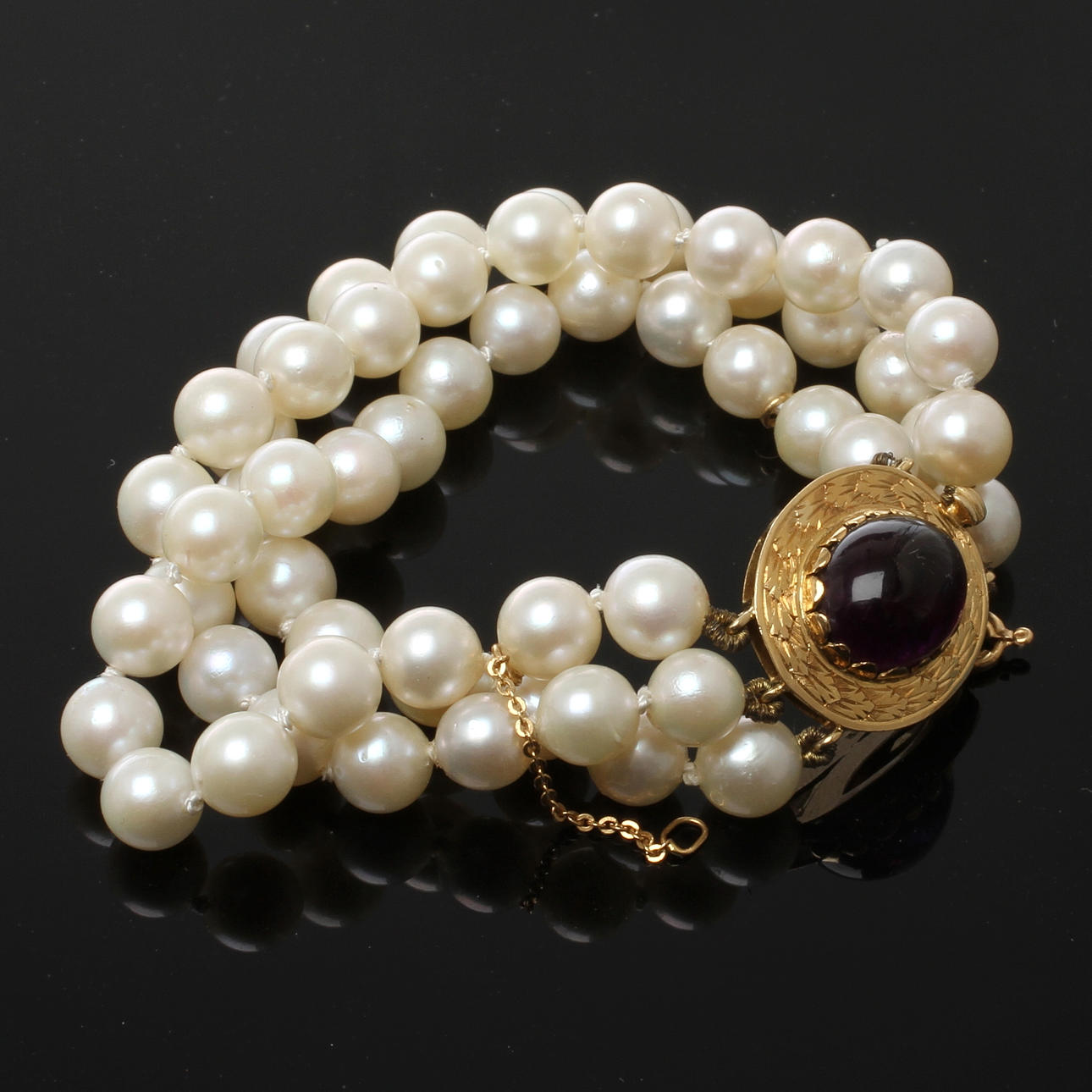 ARMBAND, odlade pärlor med lås i 18k guld, cabuchonslipad lila sten, 1900-tal.