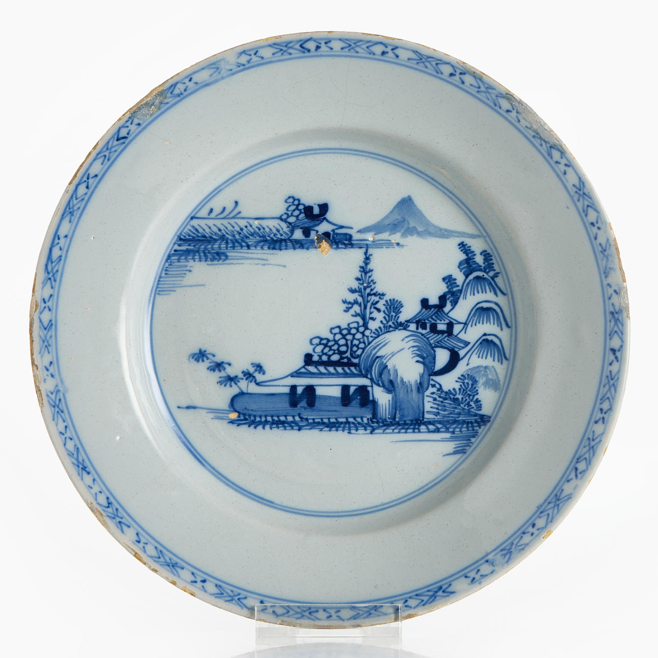 A Netherlands/Netherlands faience plate, second half of the 18th century, blue-white decor of a Chinese river landscape.