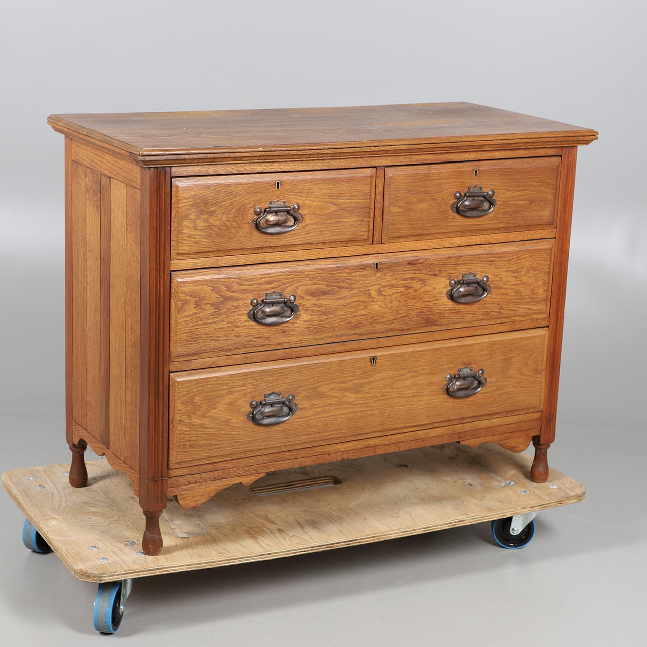 EINE EICHENKOMMODE AUS DEM FRÜHEN 20. JAHRHUNDERT MIT VIER SCHUBLADEN.