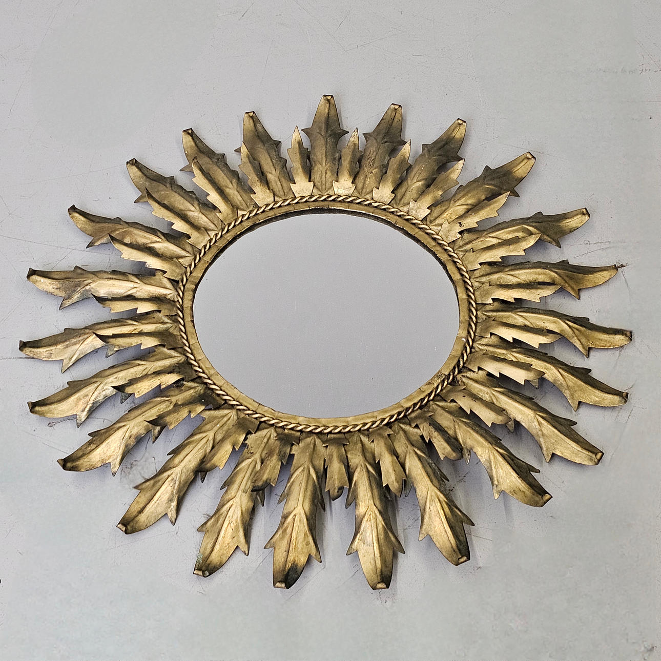 SUN-SHAPED MIRROR IN WORKED METAL.