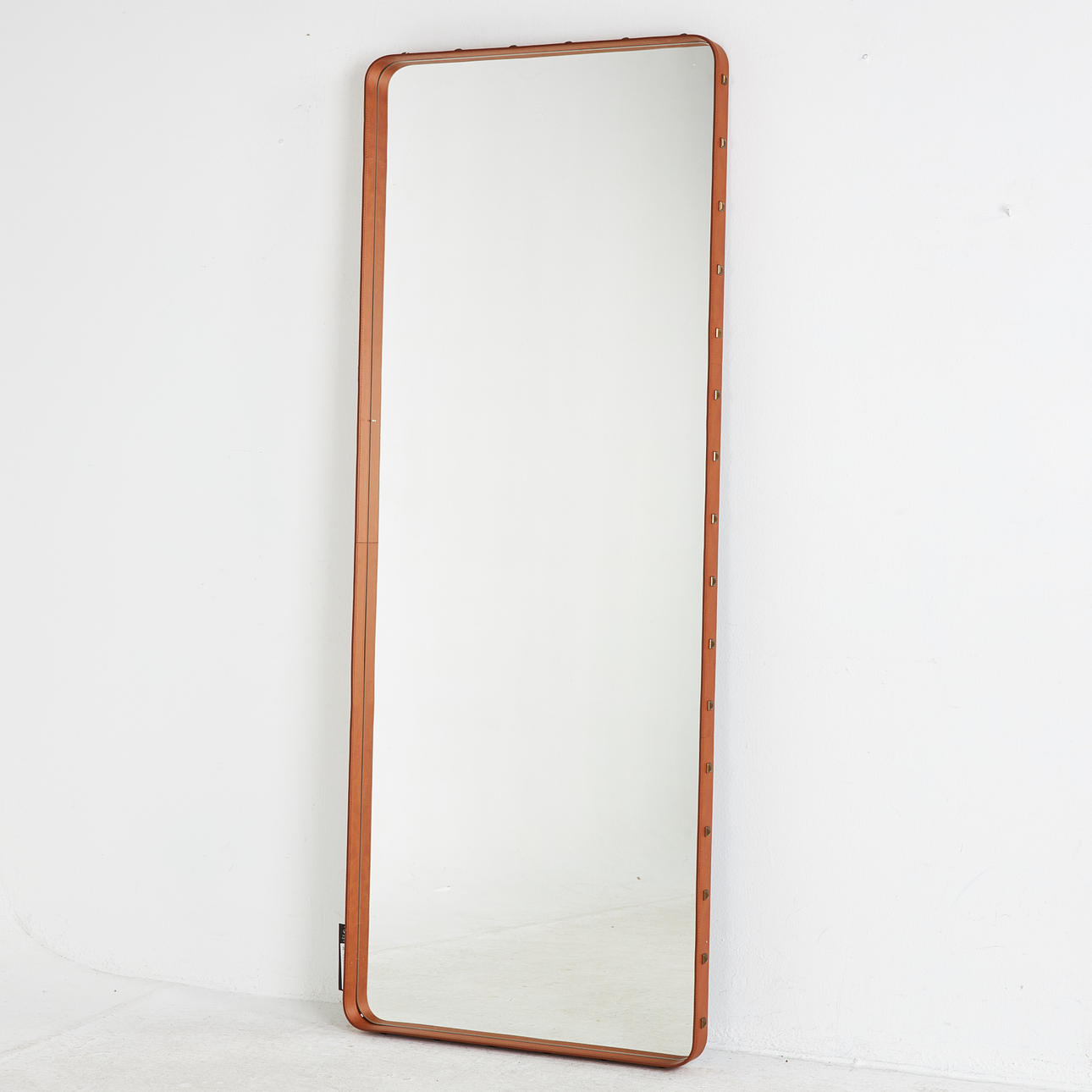 JACQUES ADNET. “Adnet”, mirror, for Gubi, upholstered in cognac leather.