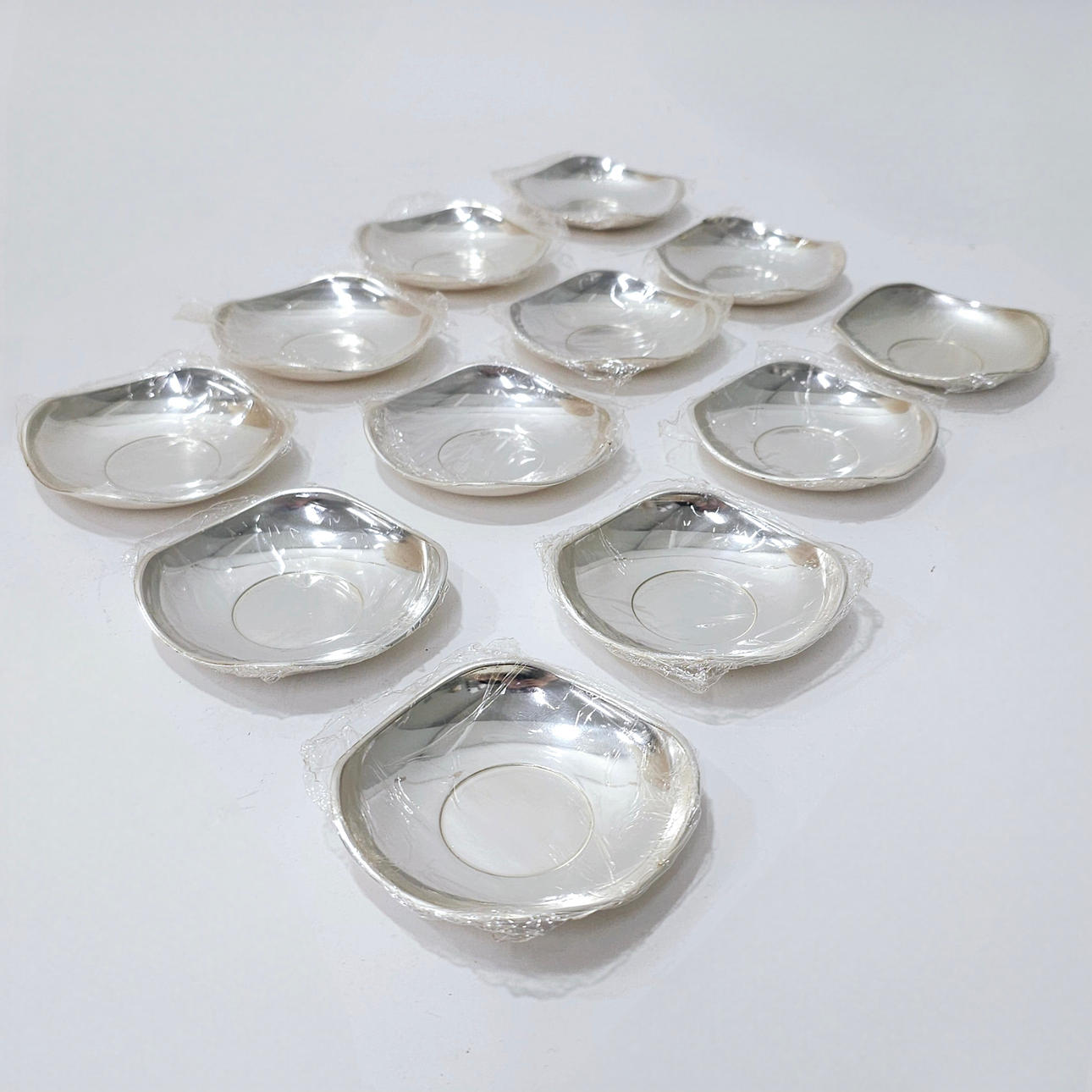 SET OF TWELVE ALPACA BREAD PLATES WITH SILVER PLATING.