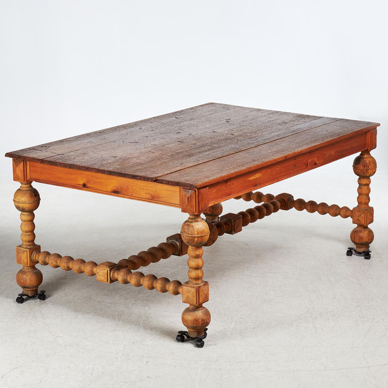 A 20th-century pine dining table with turned legs.