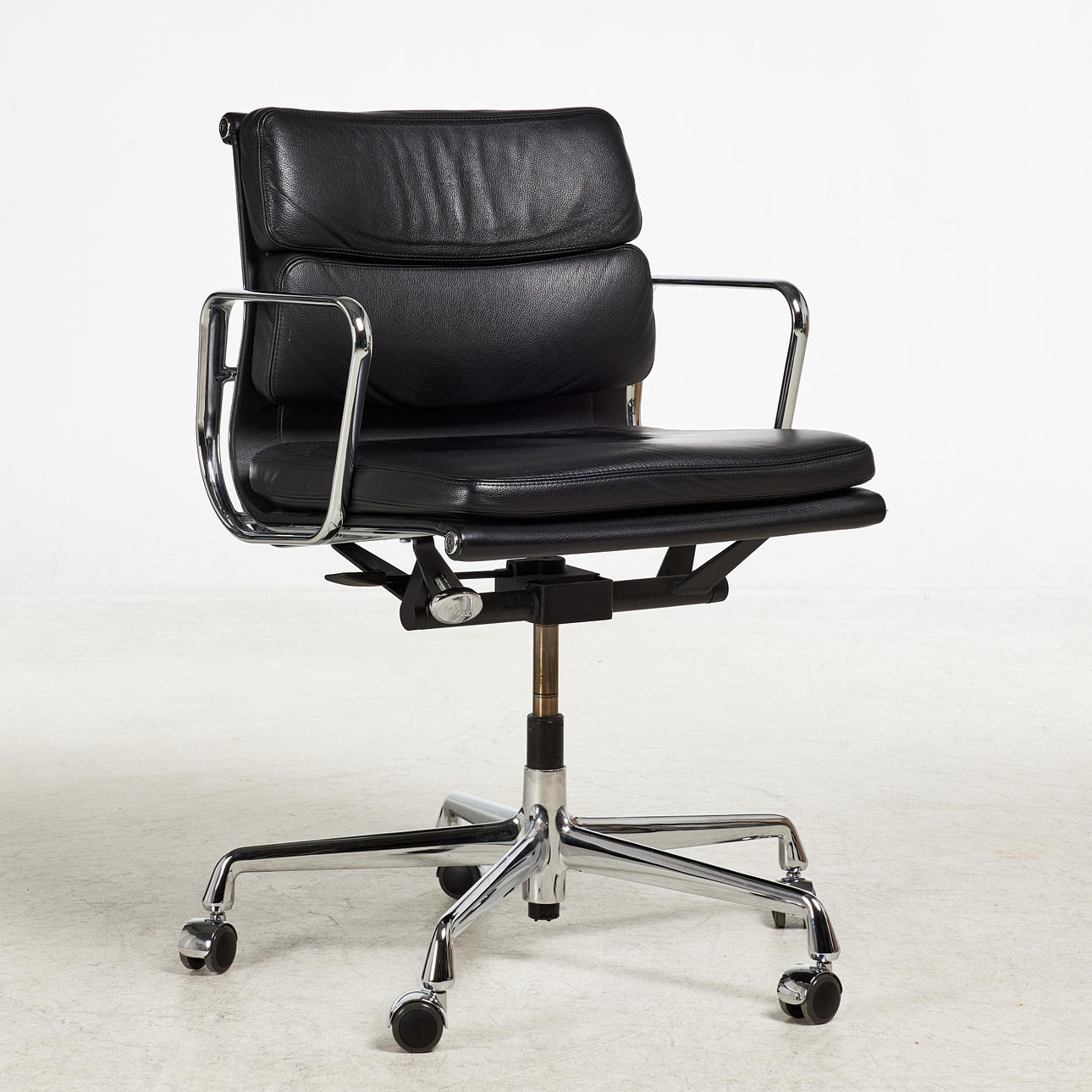 CHARLES & RAY EAMES. Kontorsstol, "modell EA 219 Soft Pad", förmgiven 1958, samtida tillverkning för Vitra, låg rygg. Svart skinnklädsel, stomme kromad aluminium, armstöd, fempassfot med hjul, vippfunktion. Etikettmärkning.