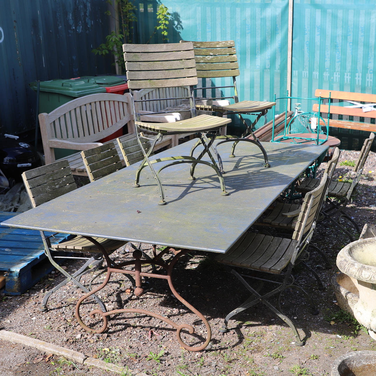 EIN SCHMIEDEEISERNER GARTENTISCH MIT METALLPLATTE UND 8 KLAPPSTÜHLE.