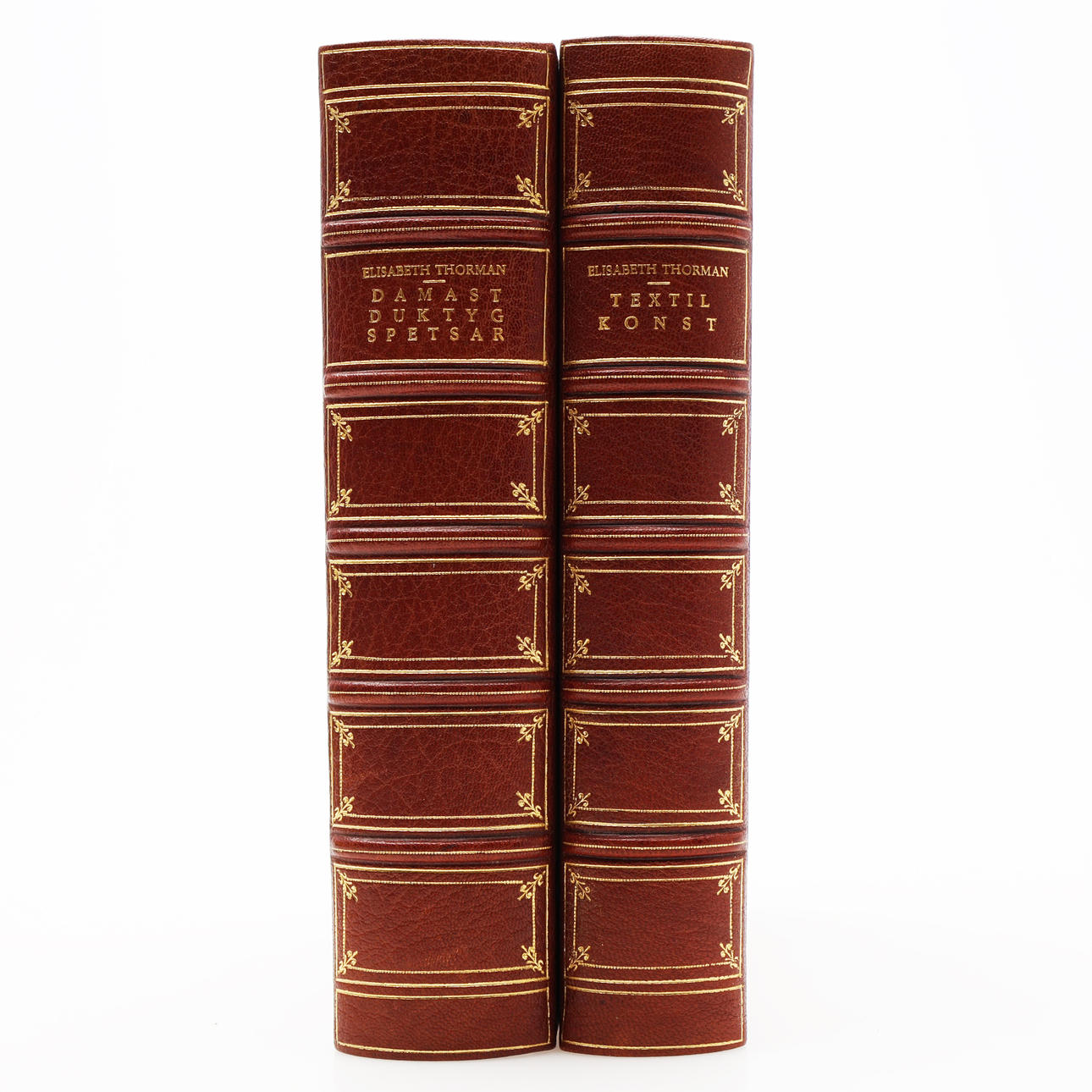 TEXTILES. TWO FULL COLLECTION BANDS WITH WORKS ON TEXTILES BY TEXTILE RESEARCHER ELISABETH THORMAN IN TWO WELL-TIED RED SEMI-MOROCCAN BINDINGS WITH DEDICATIONS TO THE ARTIST STIG BORGLIND.