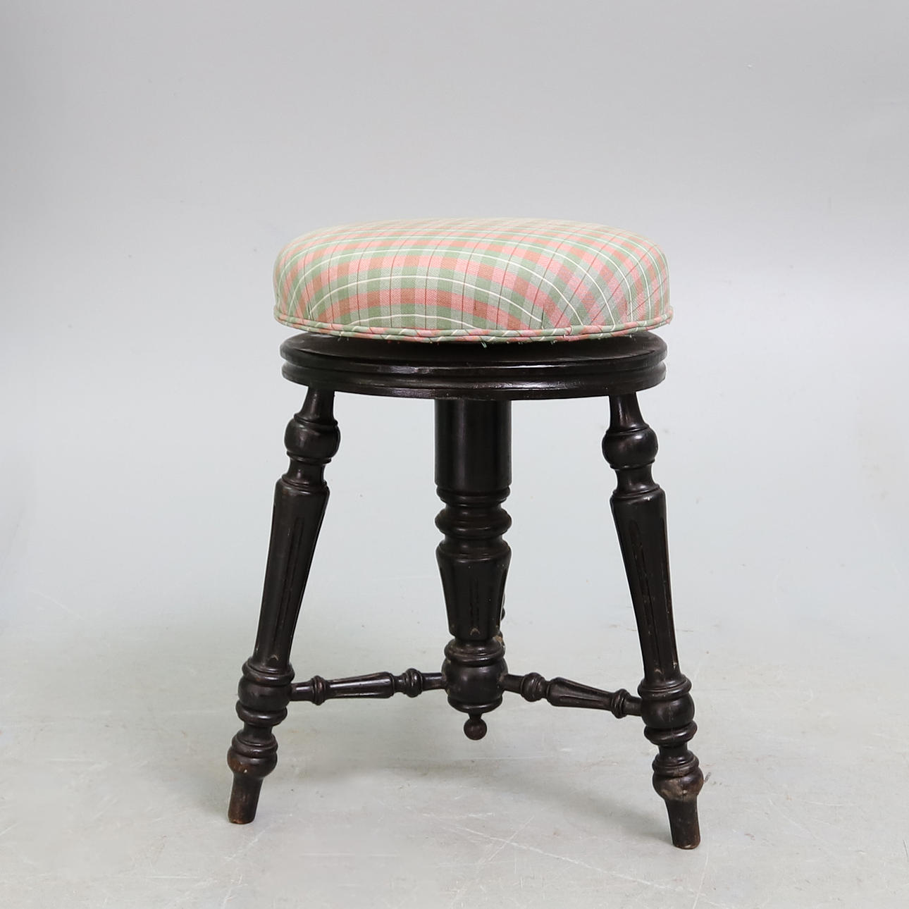 A LATE VICTORIAN EBONISED PIANO STOOL.