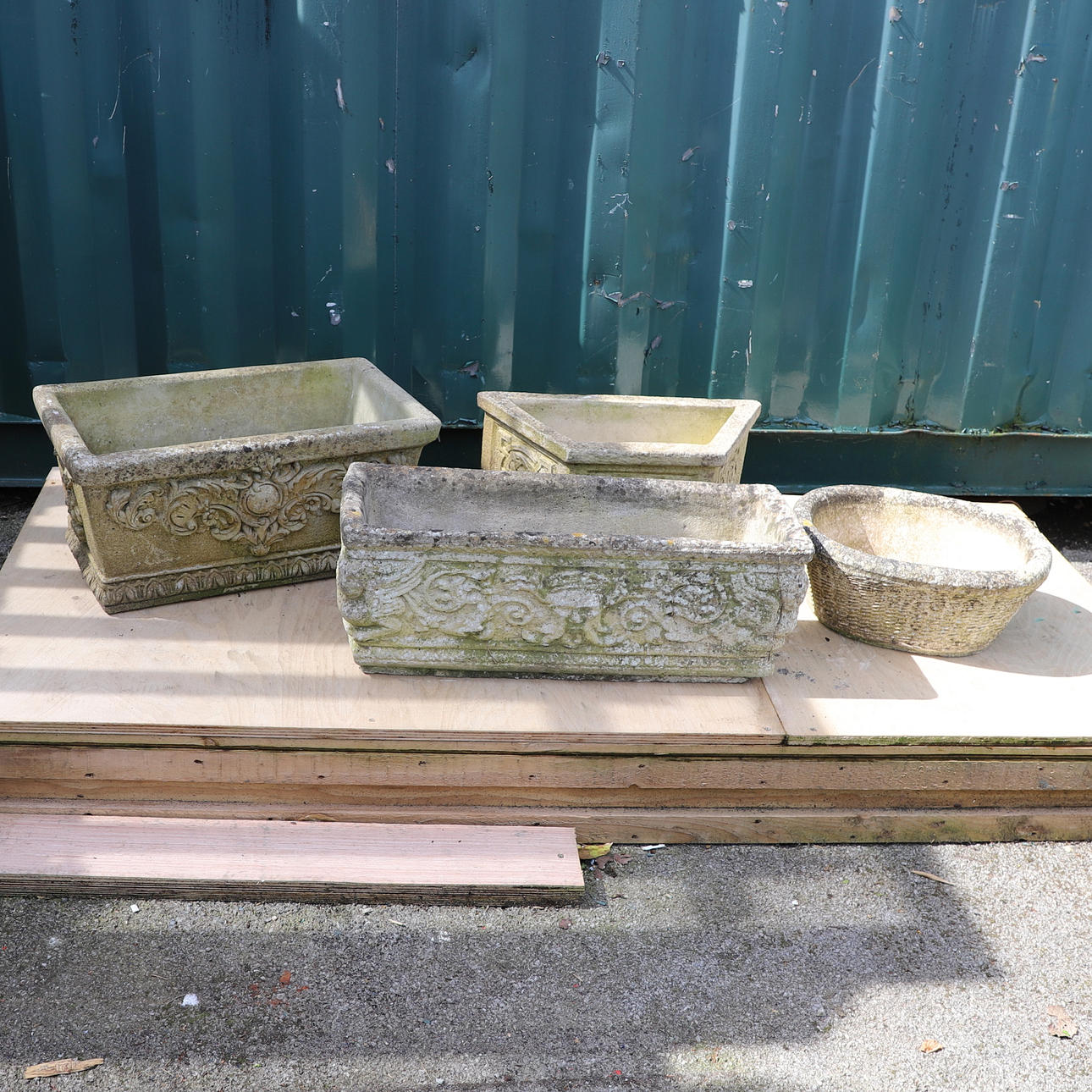FOUR RECONSTITUTED STONE GARDEN PLANTERS.
