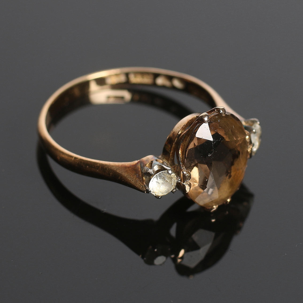 RING, 18k guld med ovalslipad rökkvarts och vita stenar, Aktiebolaget Bernhard Hertz, Stockholm, 1897. Totalvikt 3 gram.