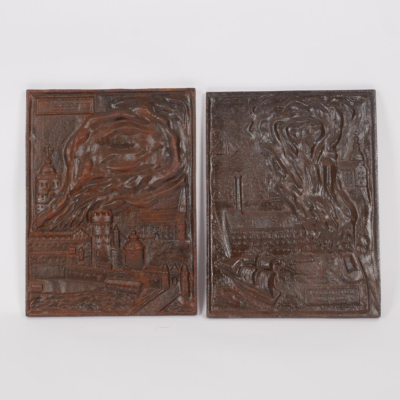 2 gusseiserne Reliefs/Herdplatten, „Tre Kronors fire“ und „Eldqvarns fire“.