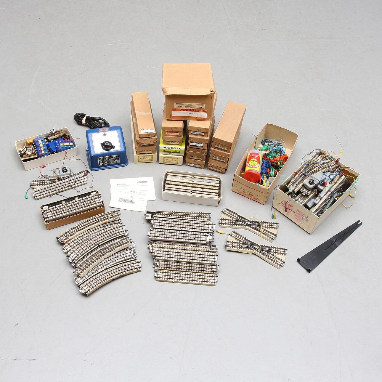 MÄRKLIN Räls, växlar, trafo med mera. Äldre variant med heldragen mittledare. Några med punktkontakt. Delvis originalkartong.