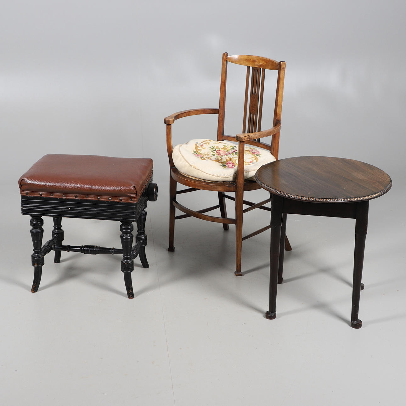 EIN HÖHENVERSTELLBARER, EBONISIERTER KLAVIERHOCKER IM VIKTORIANISCHEN STIL, EIN EDWARDIANISCHER SESSEL AUS MAHAGONI MIT INTARSIEN UND EIN RUNDER BEISTELLTISCH AUS DEM 20. JAHRHUNDERT.