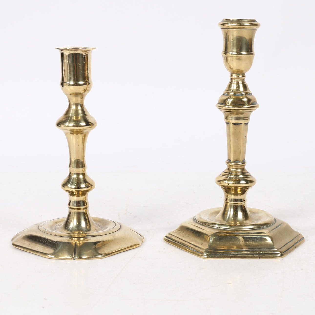 TWO GEORGE II BRASS CANDLESTICKS.