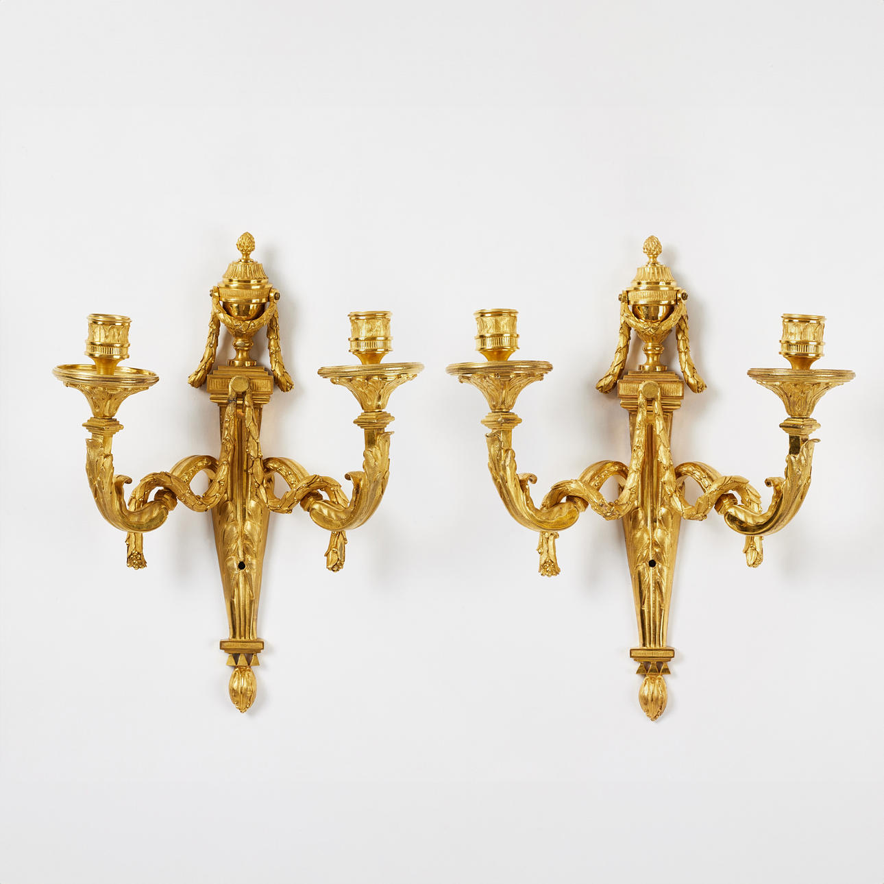 APPLIQUES, a pair of high quality works in Louis XVI, probably Paris, second half of the 18th century, art by Jean-Charles Delafosse, for two candles each, matt and polished burnished bronze.