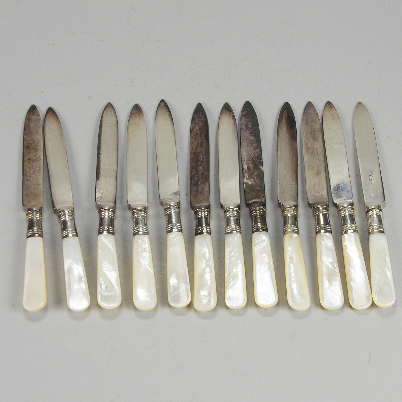 FRUKTKNIVAR, 12 stycken, nysilver med pärlemoskaft, England.