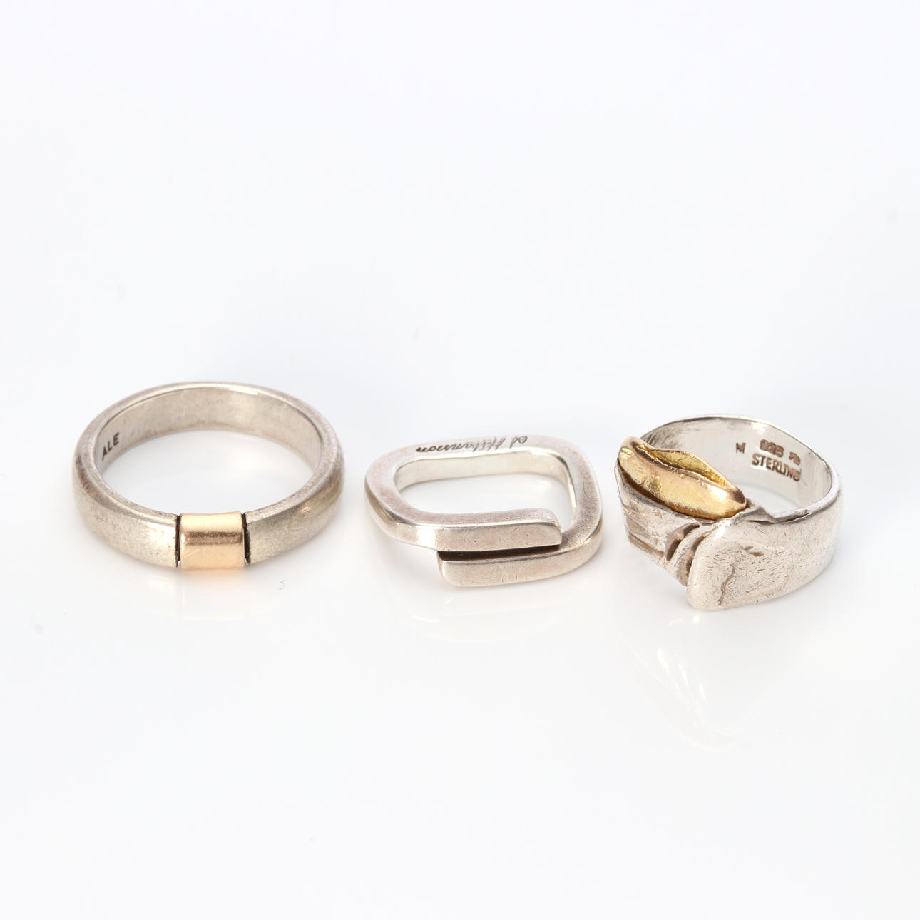 THREE STERLING SILVER RINGS WITH GOLD DETAILS.