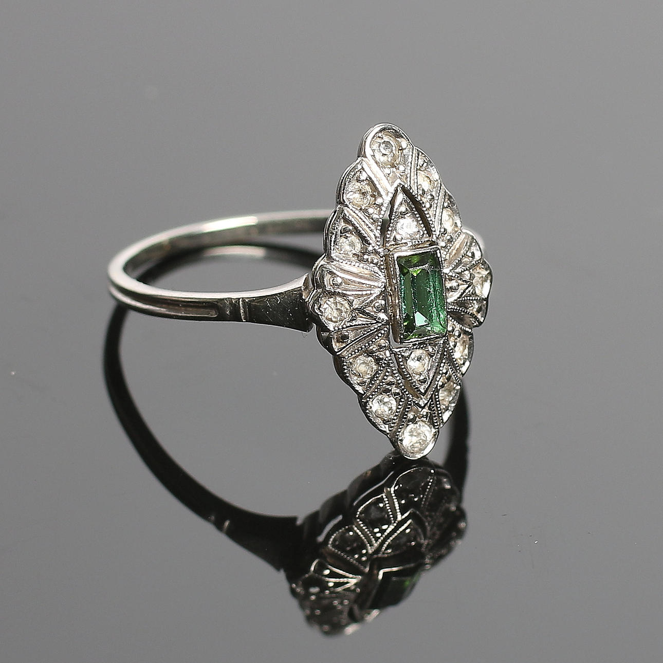RING, 18k vitguld, 14 st diamanter totalt ca 0,16 ct samt carréslipad grön sten, Art Deco, Guldvaruaktiebolaget G. Dahlgren & Co Ab. 1932. Total vikt 2 gram.
