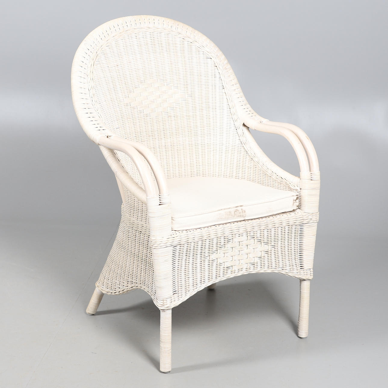 UN SILLÓN DE MIMBRE PINTADO.