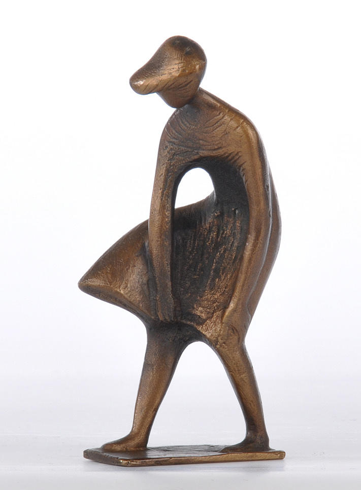 BRONZEFIGUR. En kvinna i en böjd position, ta tag i klänningen.