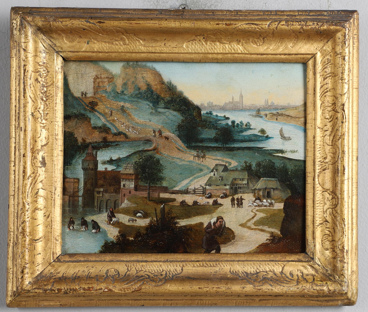 FOLLOWER OF ABEL GRIMMER (C.1570-C.1619). A MOUNTAINOUS RIVER LANDSCAPE SCENE WITH FIGURES TENDING SHEEP, A TOWN BEYOND.