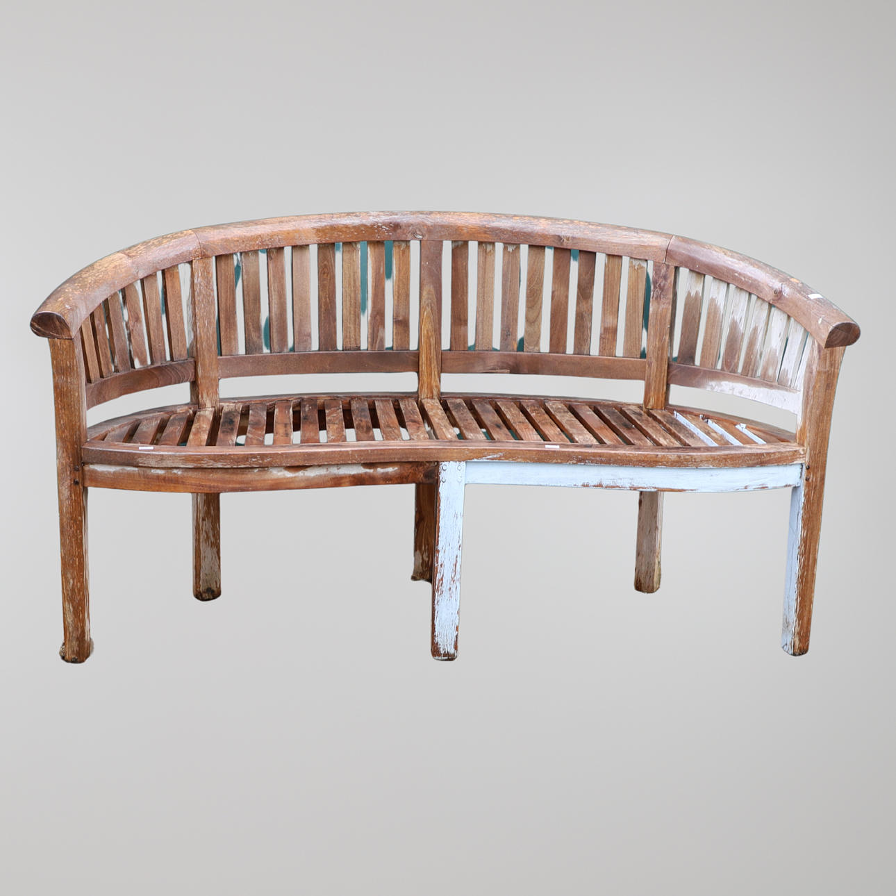 A CURVED TEAK GARDEN BENCH.