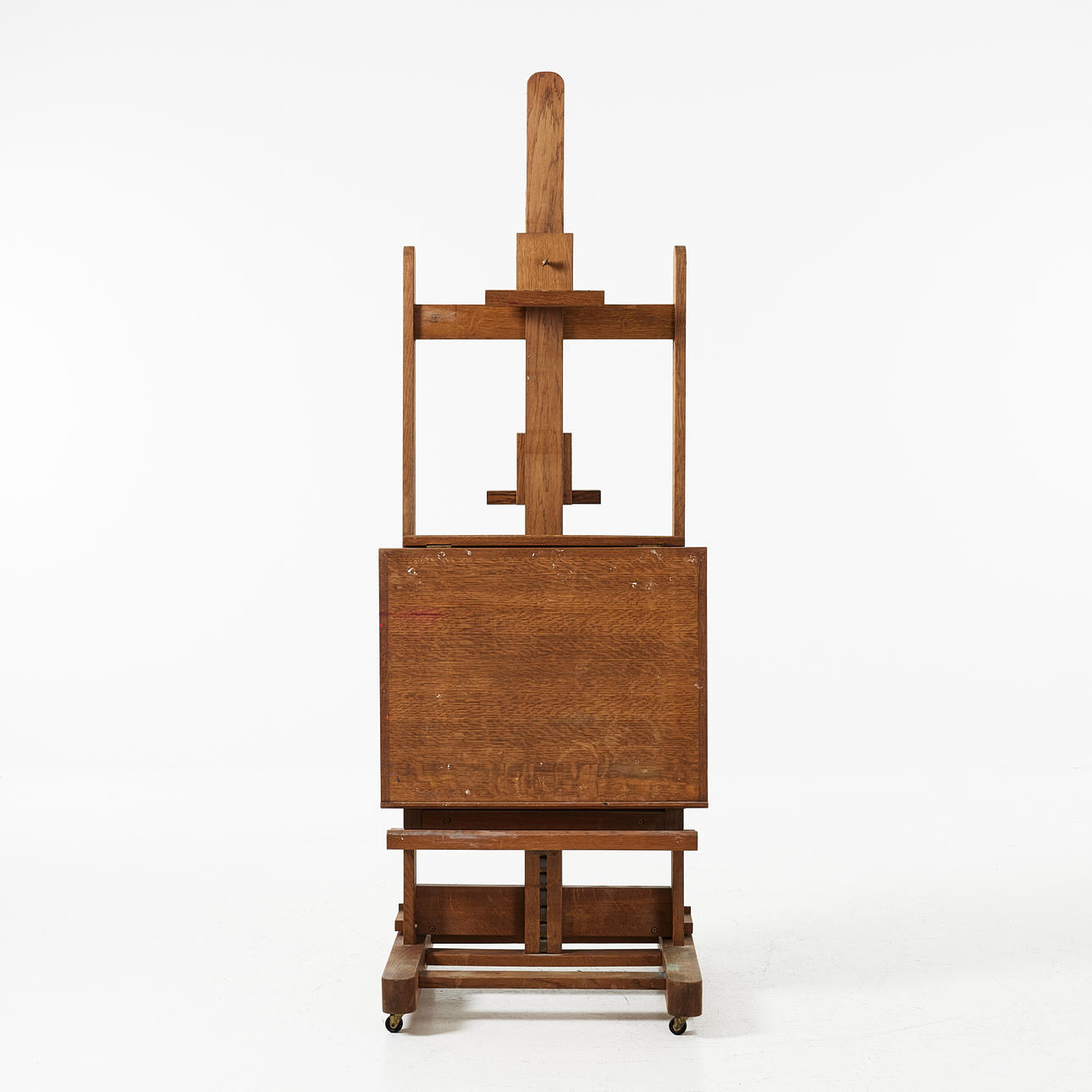 An oak easel, 20th century, cartwheels.