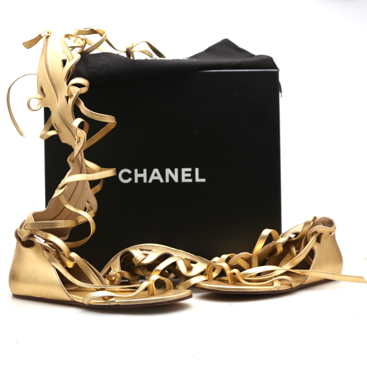 CHANEL. Höga sandaler i guldläder.