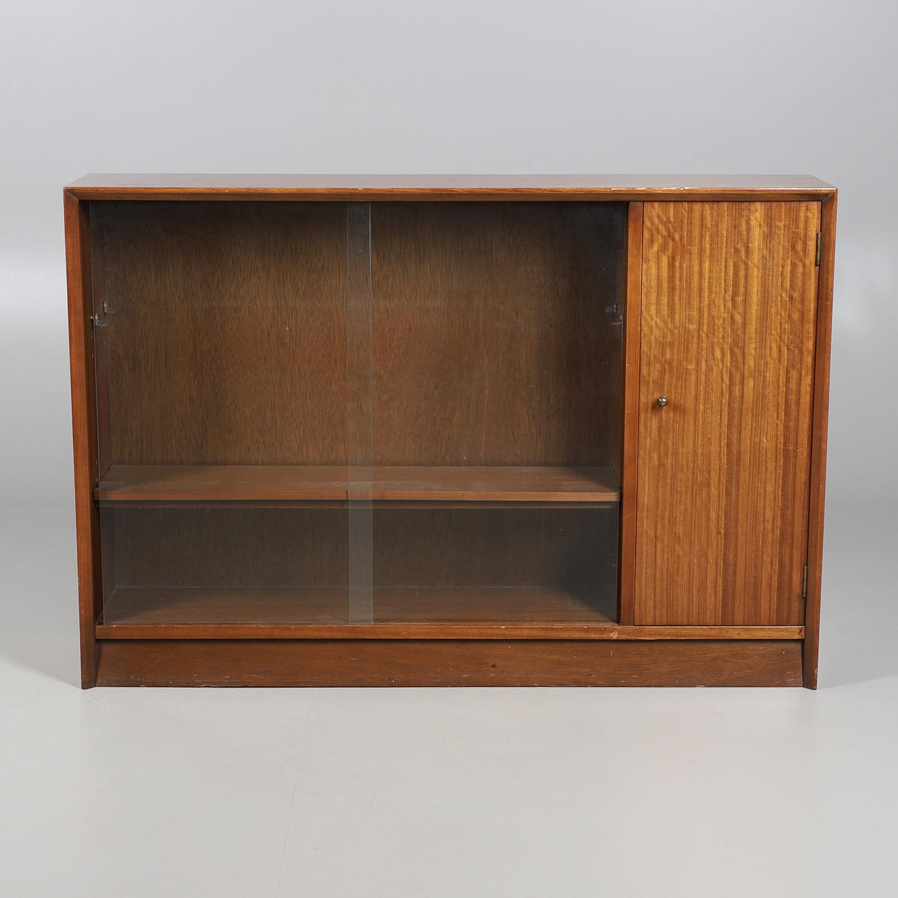 HERBERT GIBBS. EIN BÜCHERREGAL MIT GLASSCHIEBETÜR.