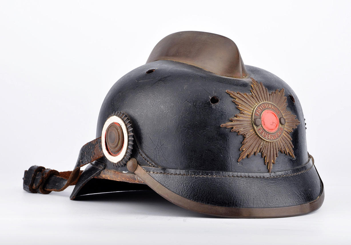 ANTIKER FEUERWEHRHELM. Läderklocka med mässingskam, kakader svart-vit-röd, prydnadsstjärna.