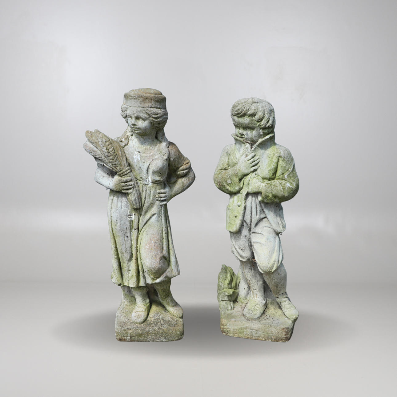 TWO RECONSTITUTED STONE GARDEN STATUES.