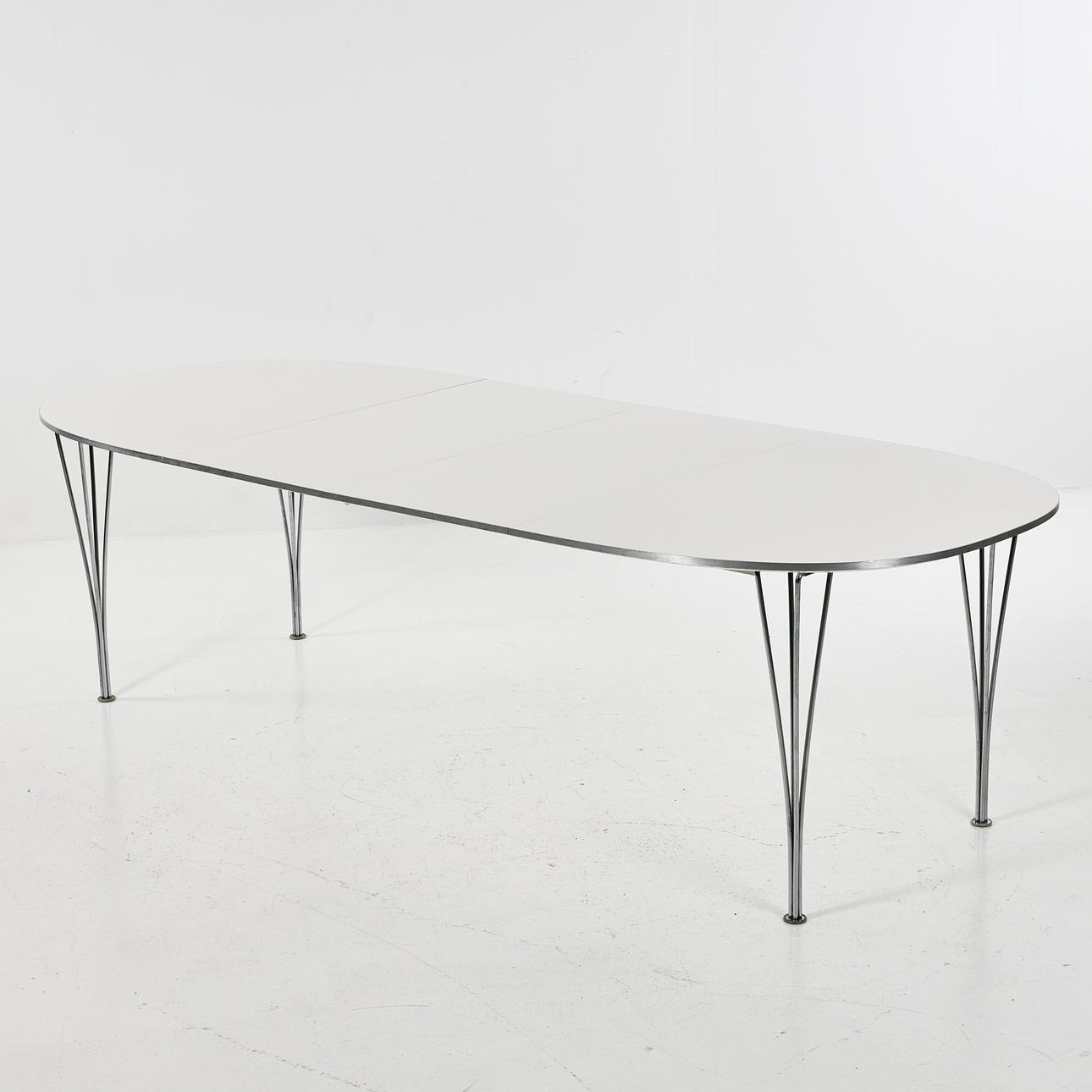 BRUNO MATHSSON & PIET HEIN. Dining table, “Superellips B618", white plastic laminate top, sash and removable legs in chrome.