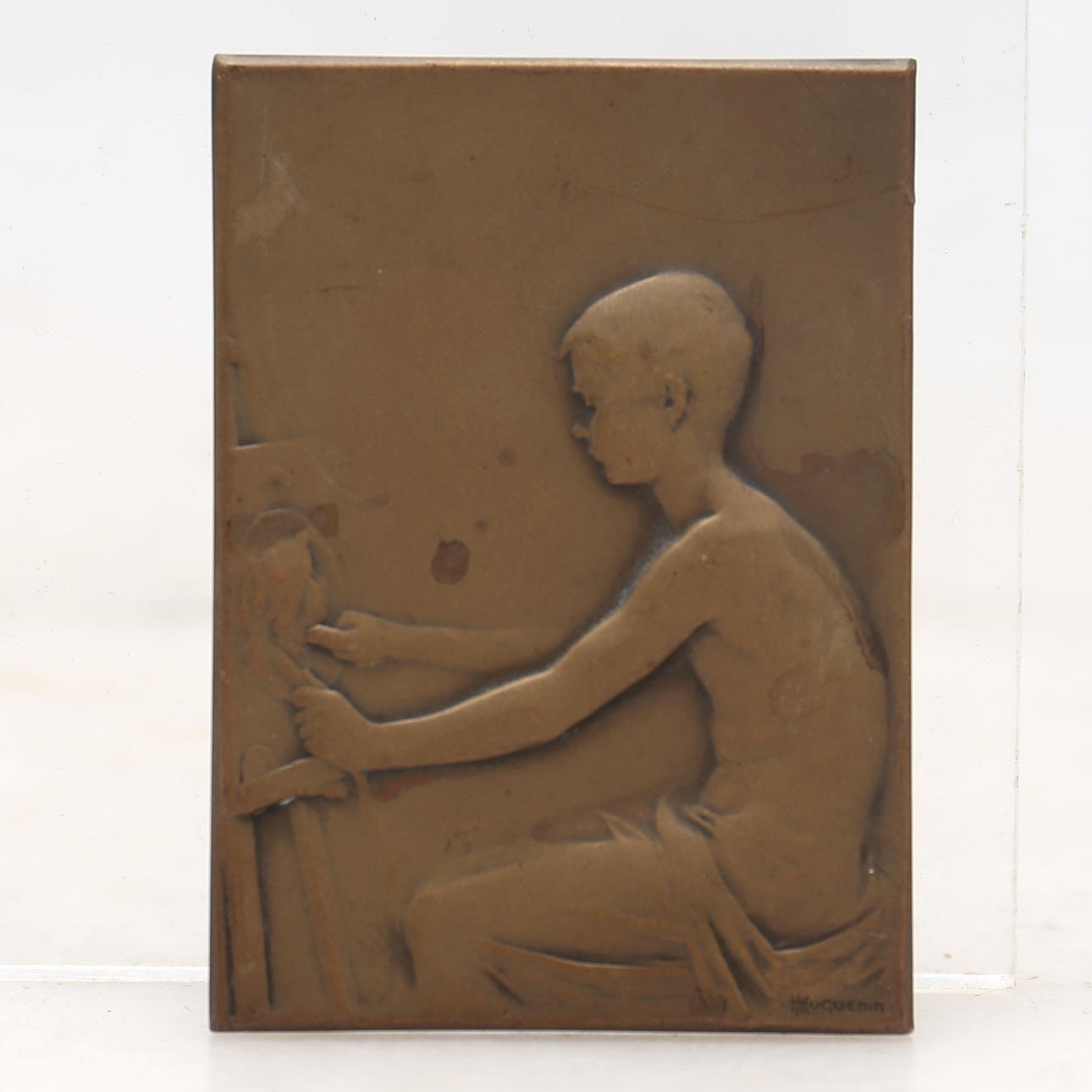 H. HUGUENIN. Boy modeling a medallion.