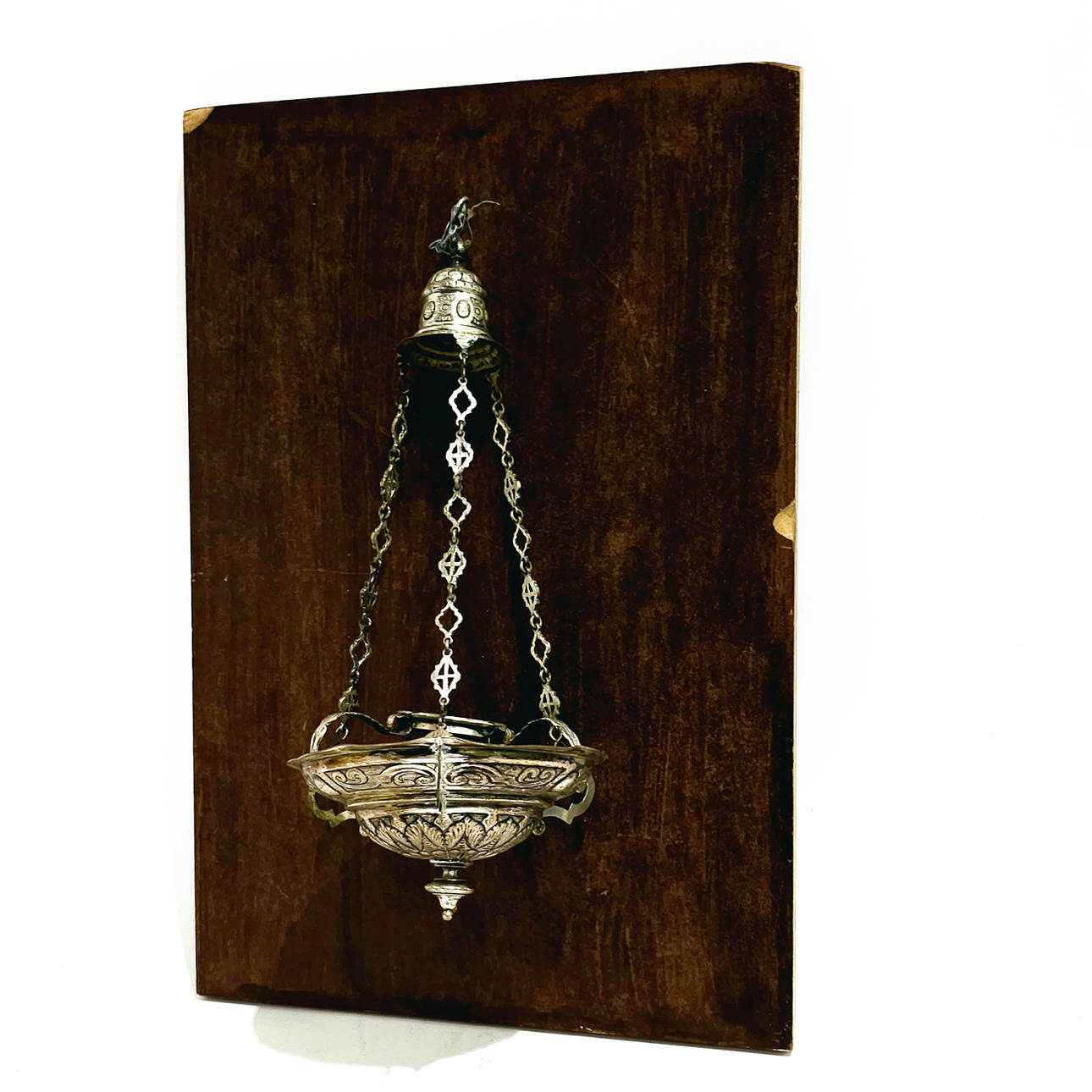 BOTAFUMEIRO EN METAL PLATEADO SOBRE PLAFÓN DE MADERA.