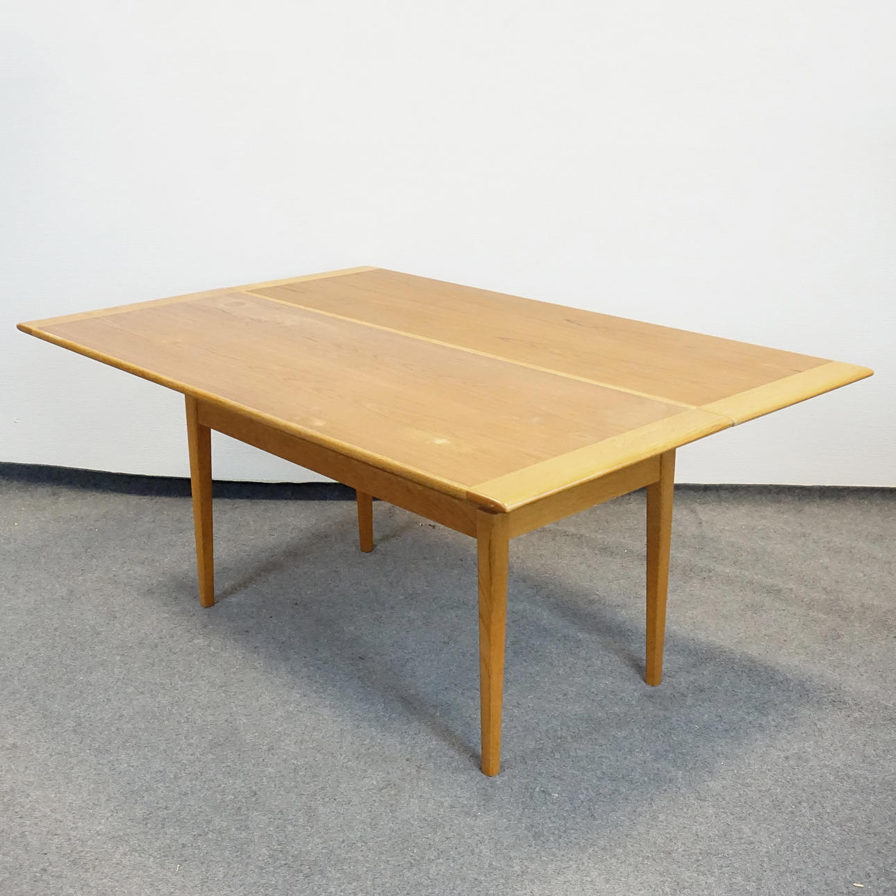 Una mesa de café/mesa de comedor de teca de mediados del siglo XX, levantada/bajada.