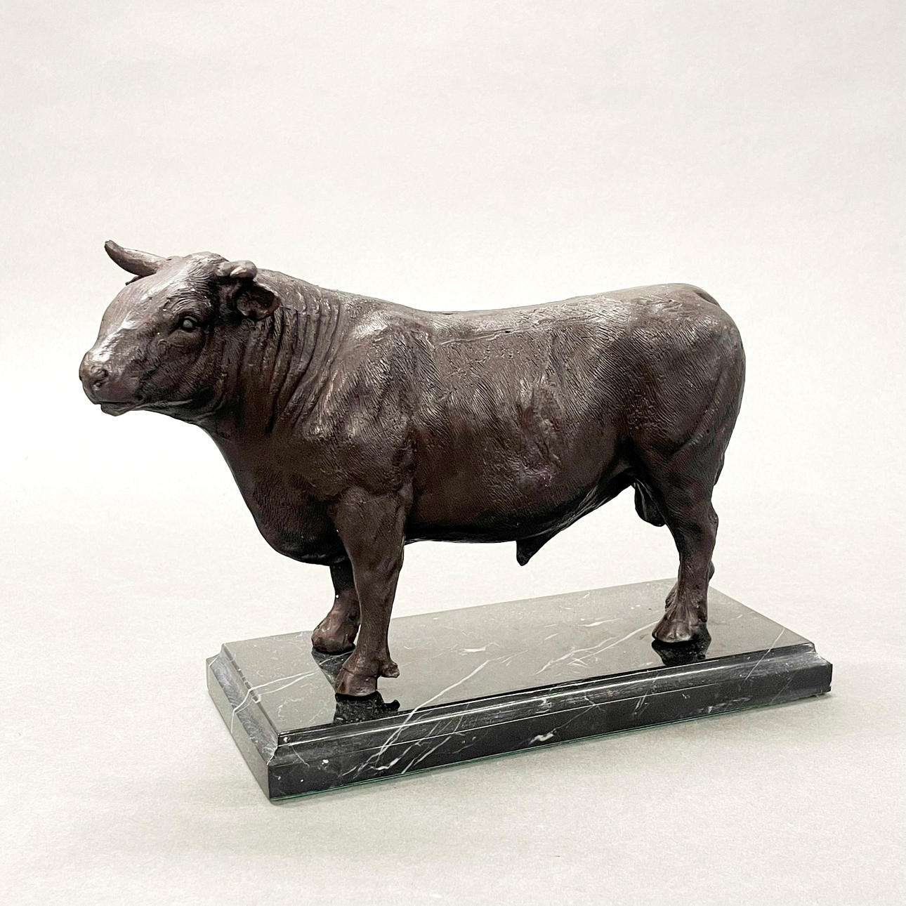 STØBT BRONZE MODEL AF EN TYR PÅ EN MARMORBASE.