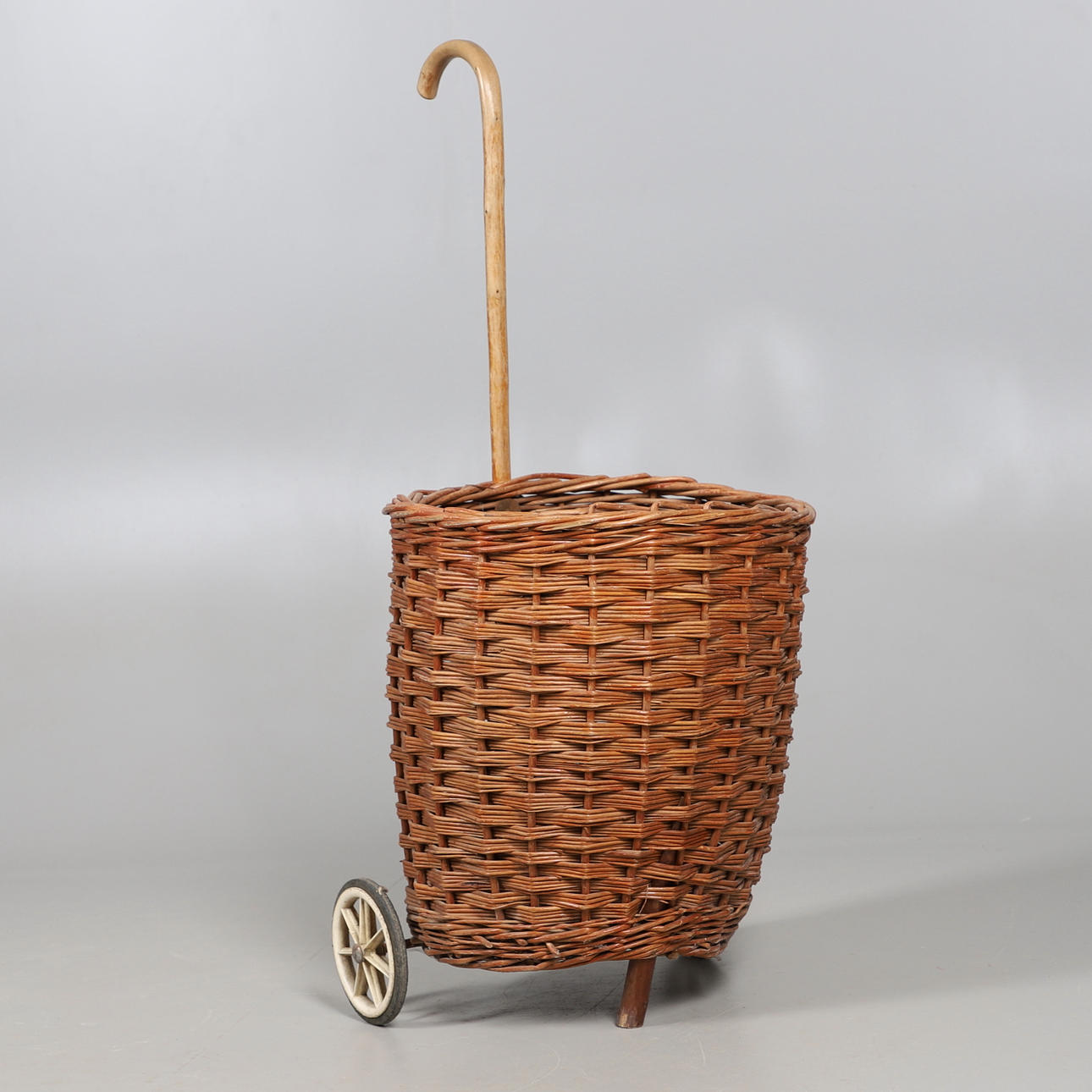 A HAND MADE WHEEL-ALONG WICKER BASKET.