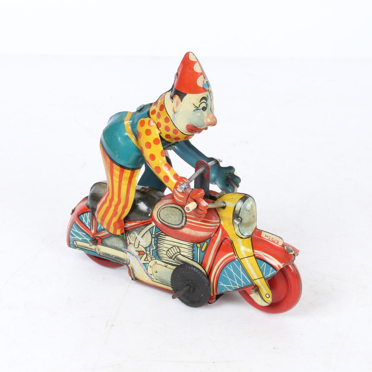 A WINDUP TINPLATE CLOWN ON A MOTORCYCLE.