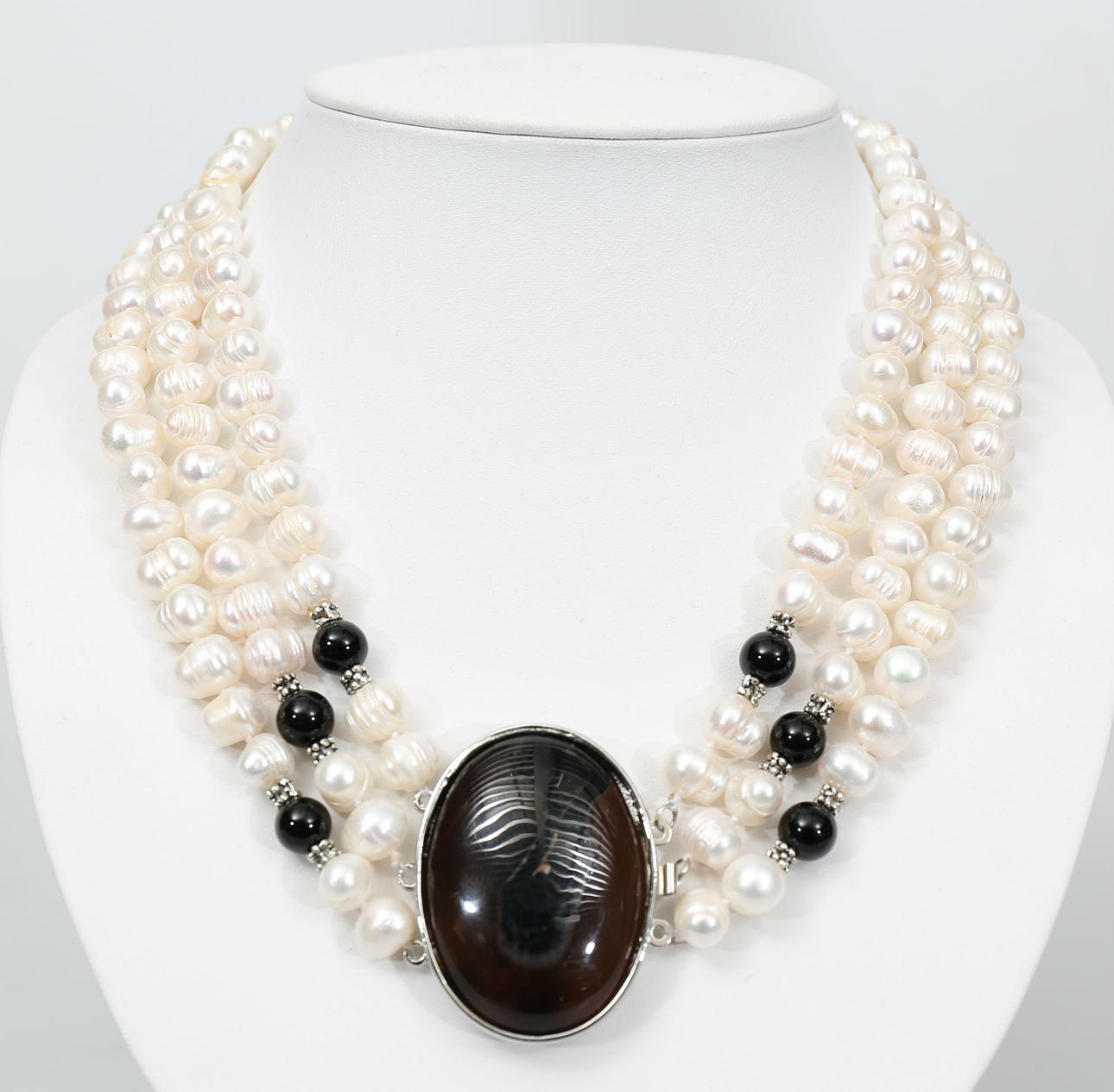 COLLIER, 3-radigt, odlade vita sötvattenspärlor och svart/brun agat, lås i vit metall, 2000-tal.