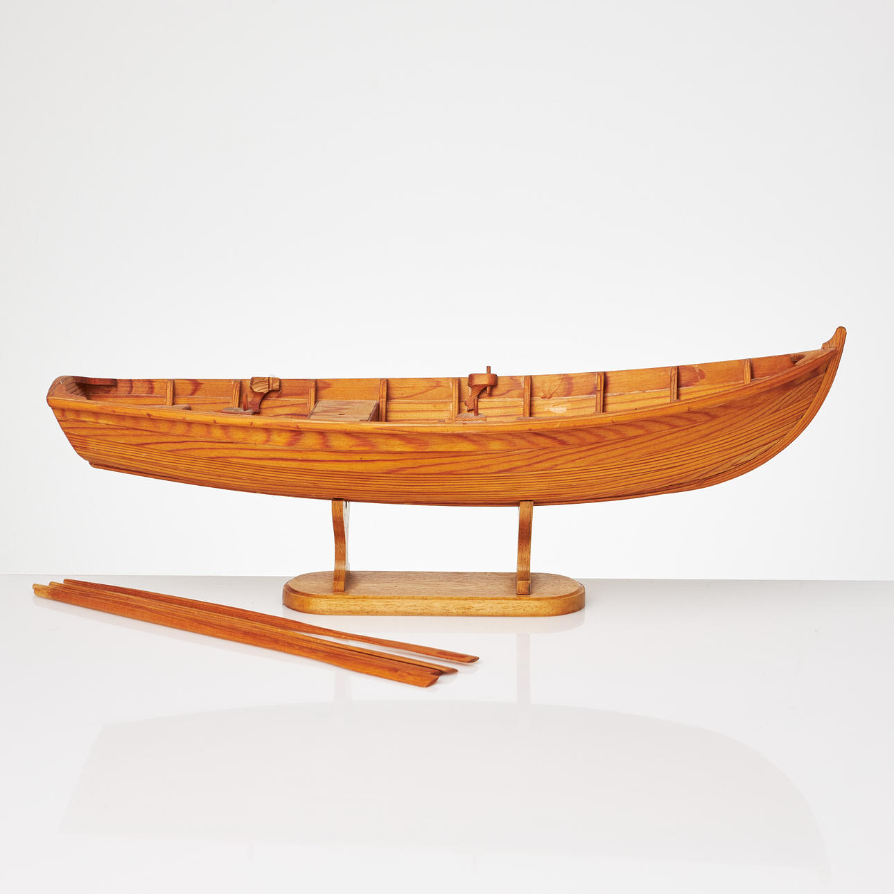 A model boat, 20th century, pine, with oars.