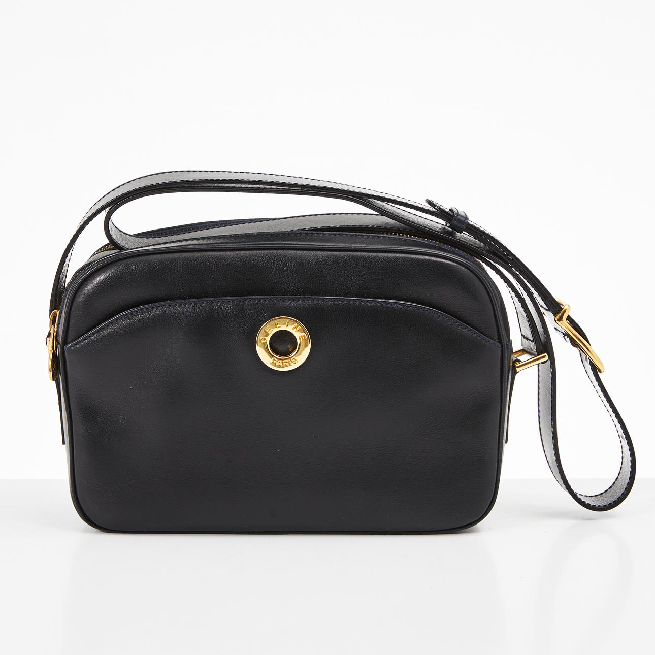 CELINE, shoulder bag in plain leather, circular push button at the front labeled CELINE PARIS.
