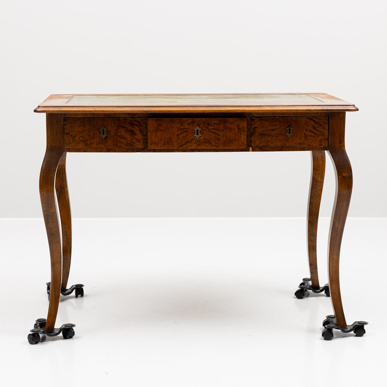 A rococo style desk with three drawers, circa 1900.